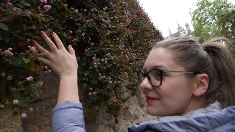 Caucasian Woman Touches Wall Of Flowers On Her Way To The Castle Slow Motion Stock Footage