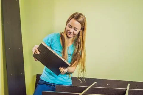 Caucasian woman using screwdriver for assembling furniture Stock Photos