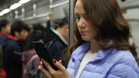 Caucasian woman using smartphone while travelling at subway in Beijing Stock Footage 106214719