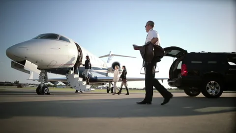 Caucasian women and pilot boarding private jet on tarmac Stock Footage 191339699