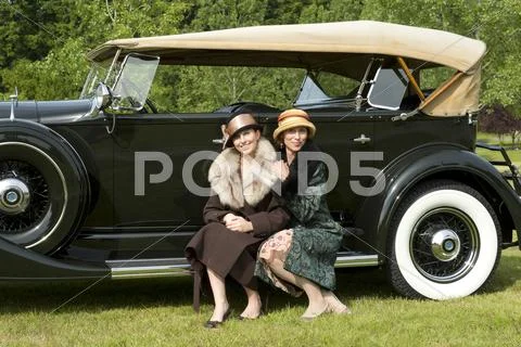 Caucasian women by vintage car Stock Photos