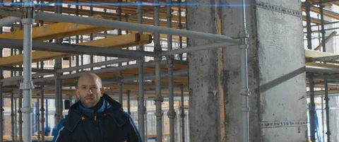 Caucasian worker puts on helmet walking on construction site. Safety precautions Stock Footage 119496747