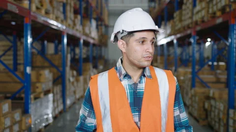 A Caucasian worker talking to the camera in the distribution warehouse Stock Footage 164238086