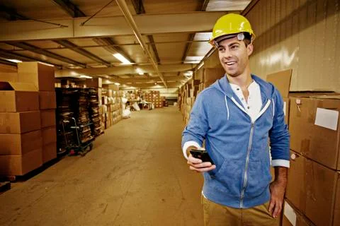 Caucasian worker using cell phone in warehouse Stock Photos