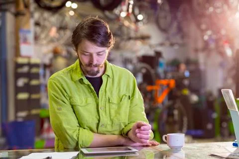 Caucasian worker using digital tablet in bicycle shop Stockfoto's