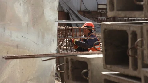 Caucasian workers in helmets uniforms create reinforced structures from iron Video stock 172237170