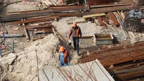Caucasian workers in helmets uniforms, group of builders walk construction site Stock Footage 172254033