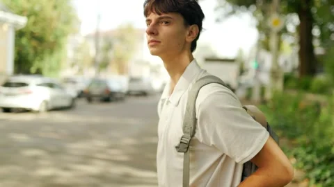 Caucasian young guy wearing a backpack standing on the city street. Vidéo 345968689