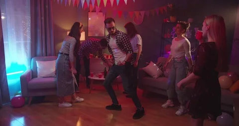 Caucasian young joyful guy in sunglasses dancing among girls and imitating Stock Footage 122505553