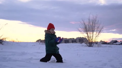 Caucasian young kid playing in the snow during cold day outdoor Stock Footage 146473589