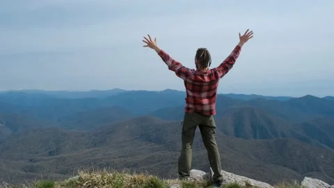 Caucasian young man with dreadlocks climbed to top of mountain Stock Footage 238894609