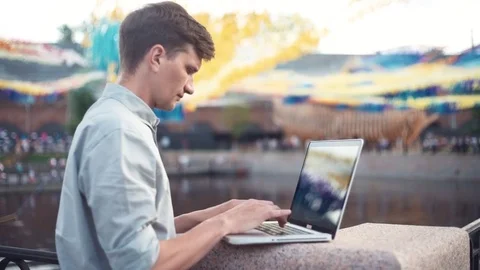 Caucasian young man using laptop standing outdoors. Summer day Stock Footage 79357016