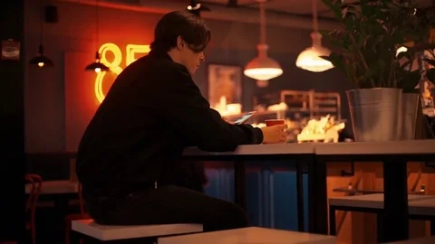 Caucasian young man using smartphone in bar in the evening Stock Footage 77168531