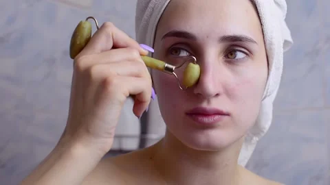 Caucasian young model without makeup, doing a facial massage using a Gua Sha sto Vídeo Stock 180496422