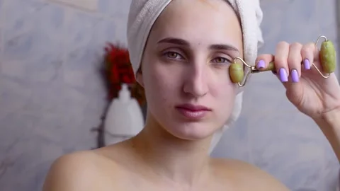 Caucasian young model without makeup, doing a facial massage using a Gua Sha sto 스톡 동영상 180499338