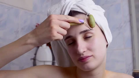 Caucasian young model without makeup, doing a facial massage using a Gua Sha sto Stock Footage 180499447