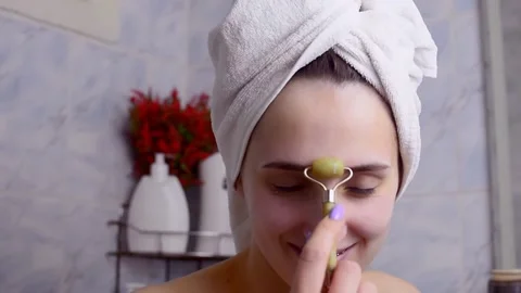 Caucasian young model without makeup, doing a facial massage using a Gua Sha sto Stock Footage 180499558