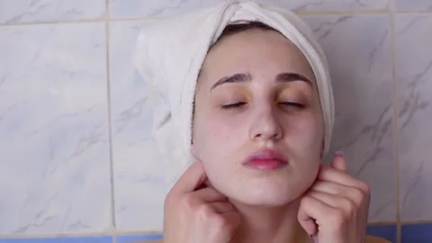 Caucasian young model without makeup, doing a facial massage using a Gua Sha sto Stock Footage 180500103