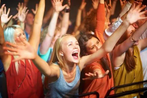 Caught up in the vibe. A huge group of fans screaming at a rock concert. Stock Photos