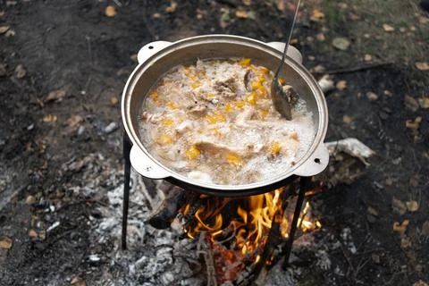 A cauldron with boiling chicken chowder made of chicken wings and vegetables Stock Photos