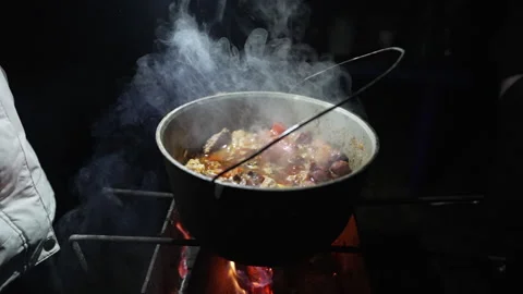 A cauldron with cooking stew is boiling, standing on the grill Stock Footage 231712803
