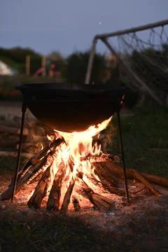 Cauldron hangs over bonfire at night, Stock Photos