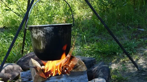 The cauldron is heated over the flame of a fire, ideal for use outdoors and at Stock Footage 279656970