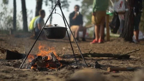 Cauldron at the stake. cooking on the fire.  young people near the fire Stock Footage 113276797