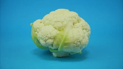 Cauliflower on a blue background rotates and leaves the frame. Stop motion Video stock 314342610