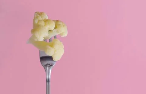Cauliflower on a fork on a pink background Stock Photos