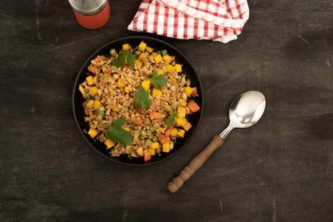 Cauliflower fried rice has vegetable in black dish on wood table. Stock Photos