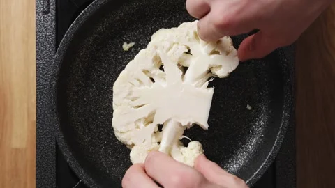 Cauliflower is placed in frying pan for cooking. Stock Footage 342105393