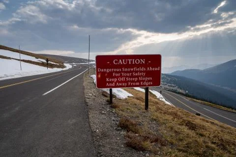 Caution - dangerous snowfields ahead sign, keep off steep slopes along Trail  Stock Photos