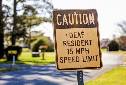 Caution deaf resident 15 mph speed limit traffic road sign at a residential n Stock Photos