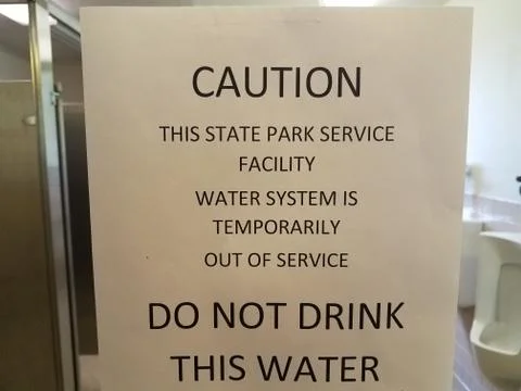 Caution do not drink this state park's water sign on bathroom mirror Stock Photos