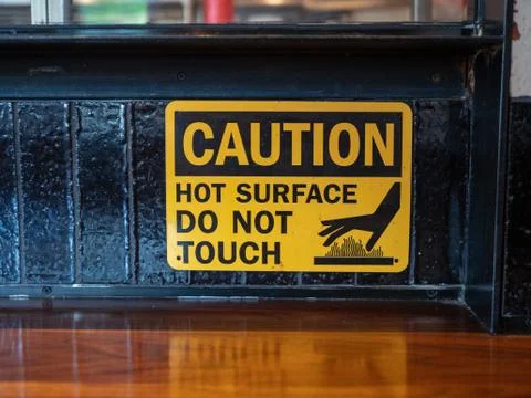 Caution hot surface, do not touch sign in front of a grill at a restaurant Stock Photos