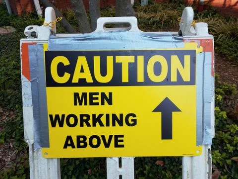 Caution men working above sign with arrow Stock Photos