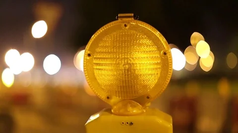 A caution sign is lit up by a blinking yellow warning light Video stock 80993751