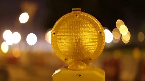 A caution sign is lit up by a blinking yellow warning light Video stock 80993761