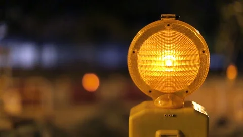 A caution sign is lit up by a blinking yellow warning light Video stock 80993786
