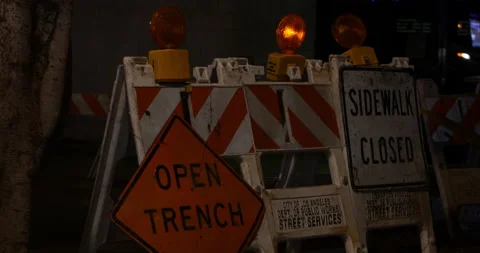 Caution signs around utility work on a road at night with flashing amber lights Video stock 149646129