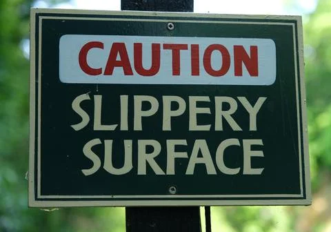 Caution slippery surface warning sign outdoors Stock Photos