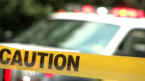 Caution Tape at an Accident Scene with Police Vehicle Behind Stock Footage
