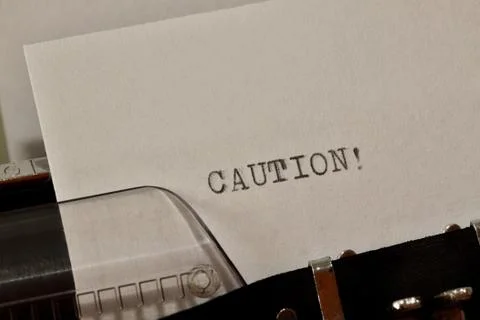 Caution text typed on old black typwriter Stock Photos