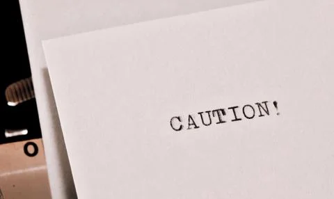 Caution text typed on old black typwriter Stock Photos