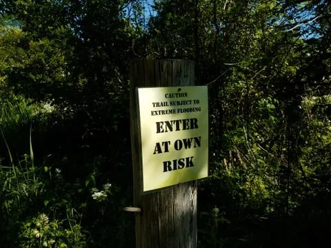Caution trail subject to flooding enter at own risk sign Stock Photos