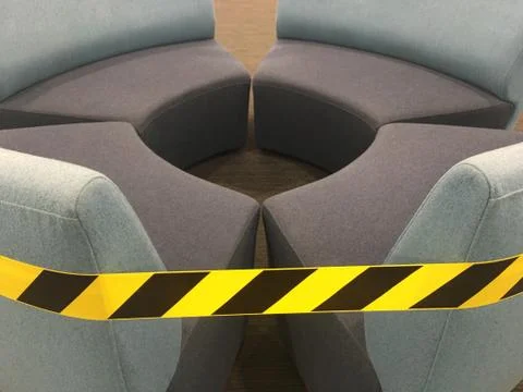 Caution warning tape on empty couches Stockfoto's