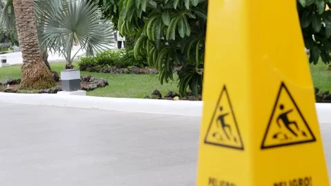 Caution: Wet Floor Sign in Tropical Garden Setting Stock Footage 316521109