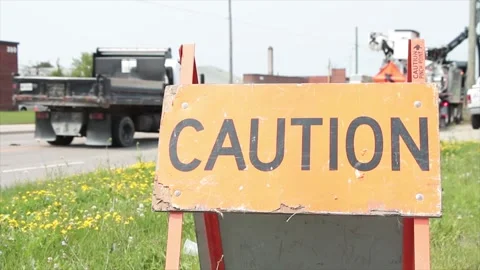 Caution word caption text sandwich board wooden sign next to sidewalk and grass Video stock 249101742