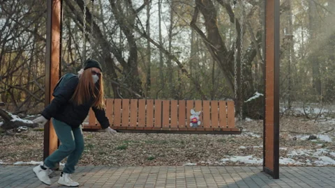 Cautious individual covertly retrieves tiny item in winter setting. Someone Stock Footage 337822187